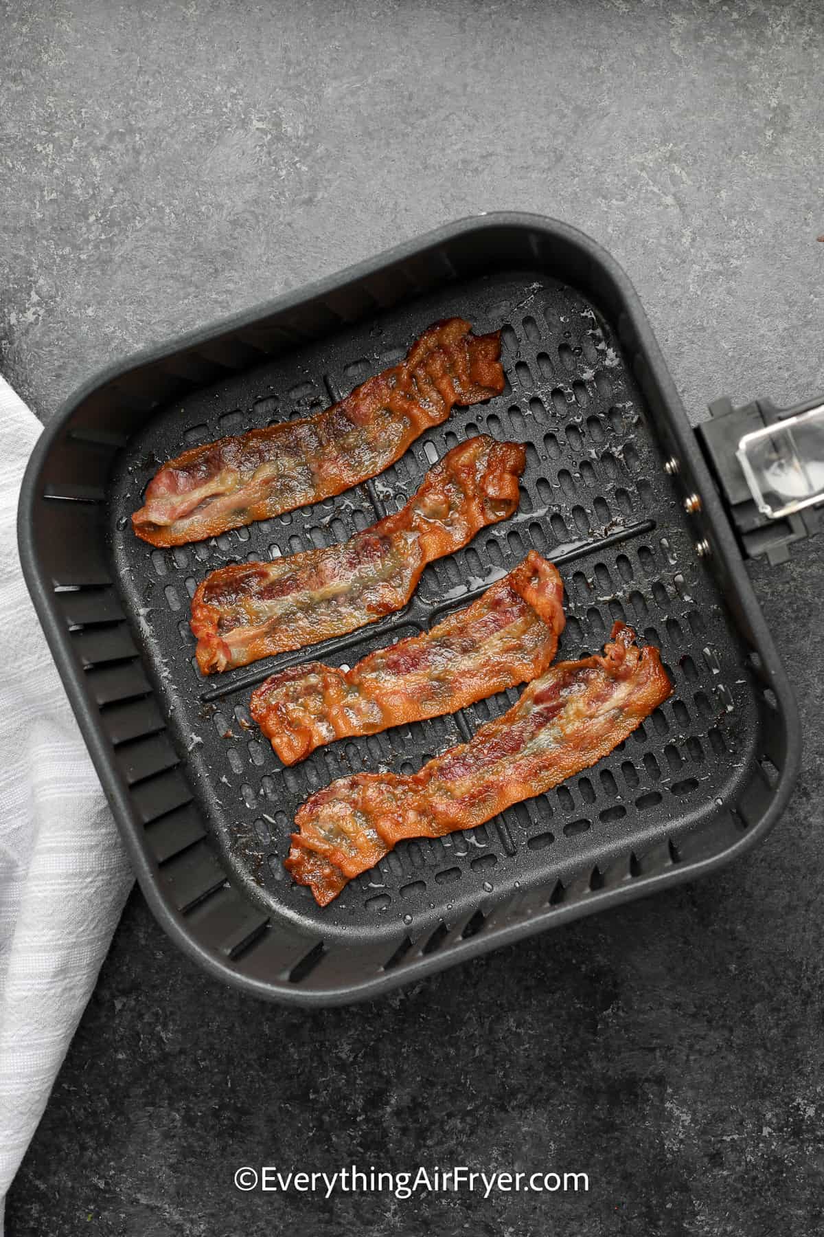 cooked bacon in an air fryer tray