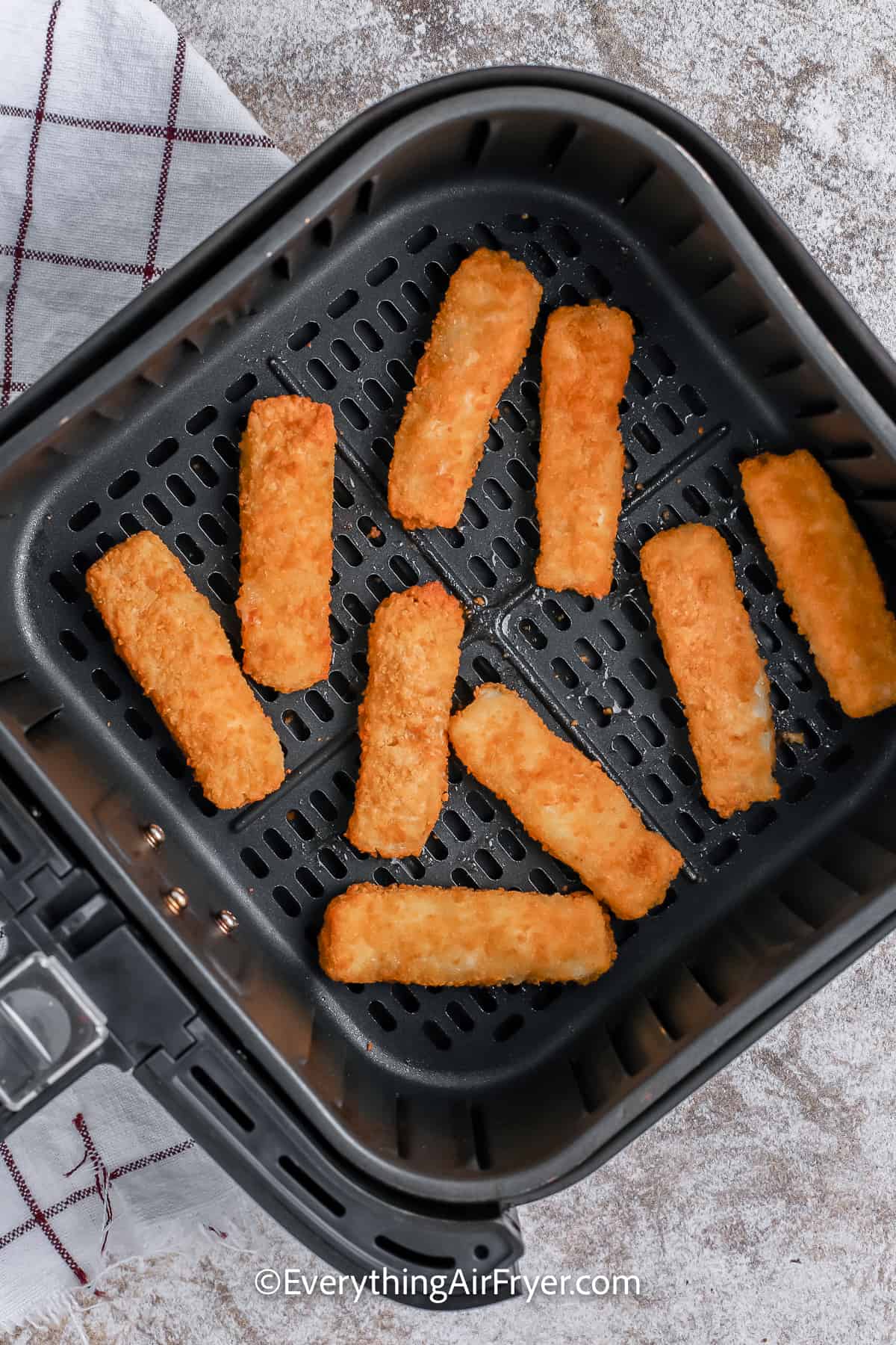 cooked fish sticks in an air fryer tray