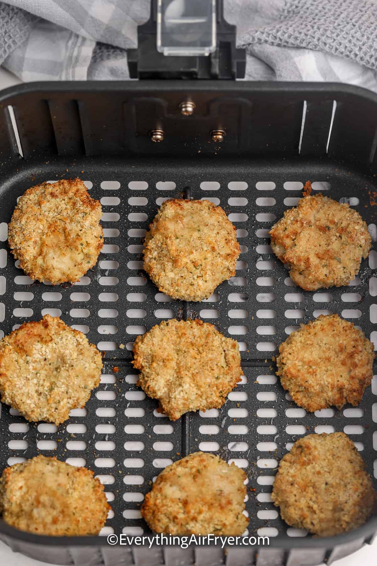 cooked homemade air fryer chicken nuggets aligned in an air fryer tray