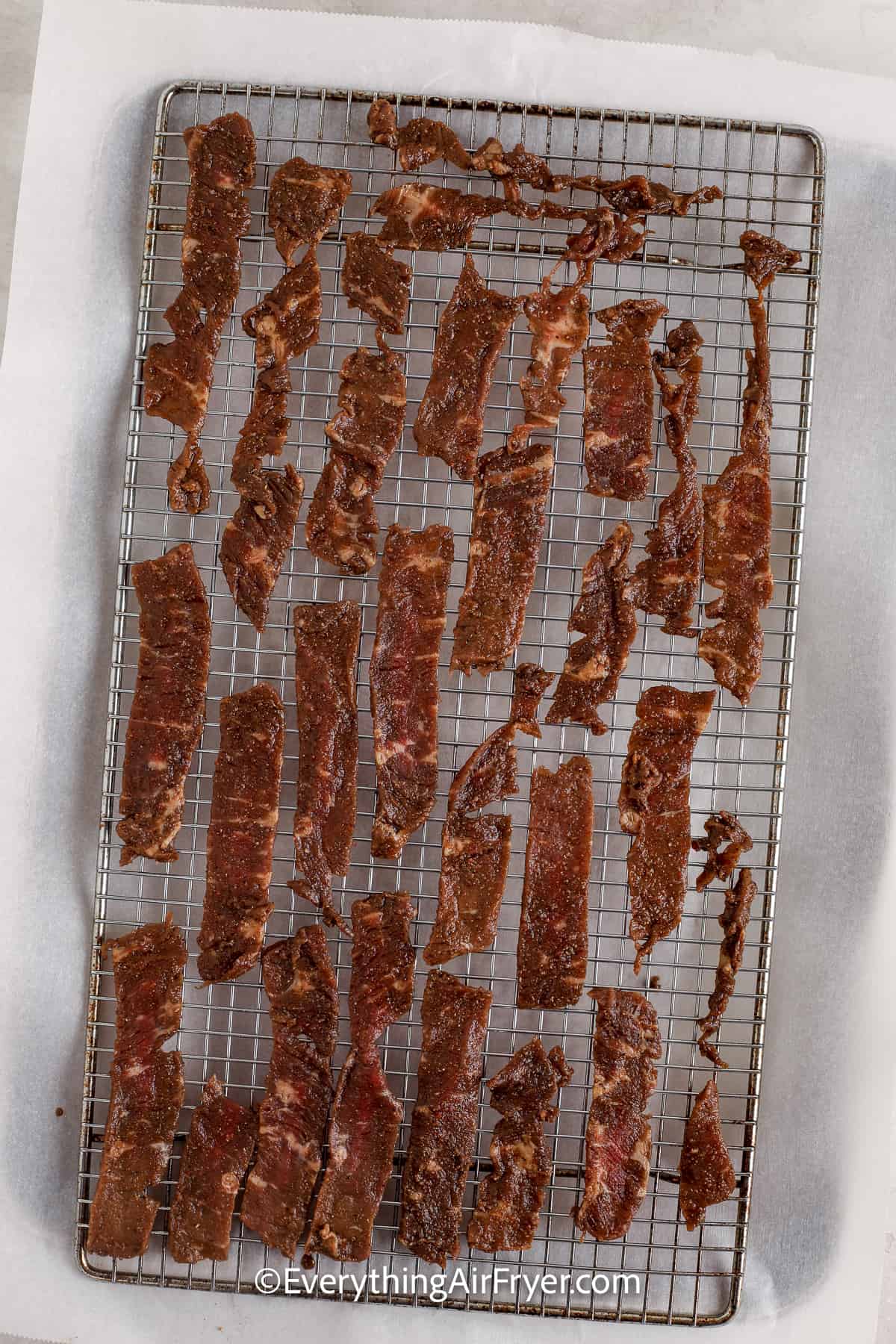 marinated steak strips on a drying rack