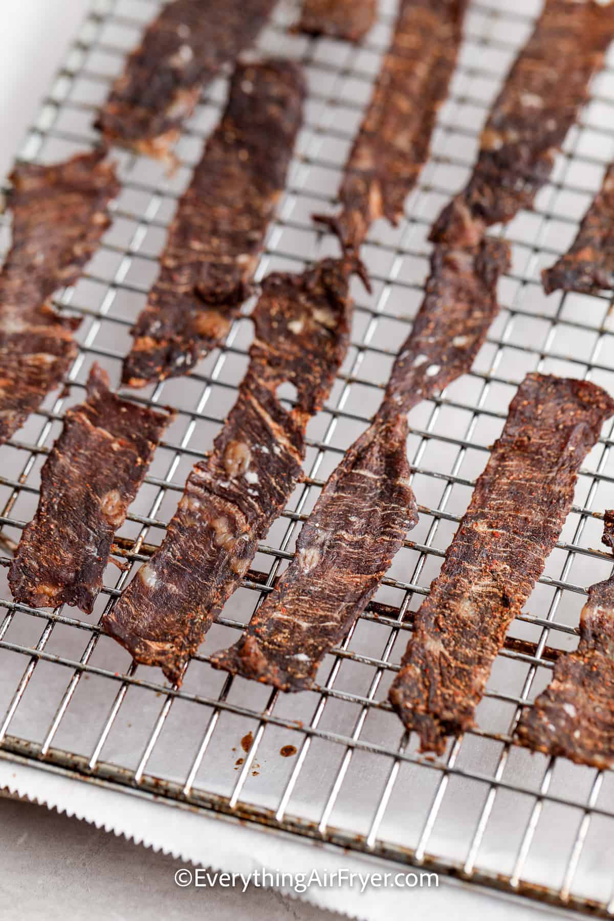 dried strips of instant vortex air fryer jerky on a drying rack