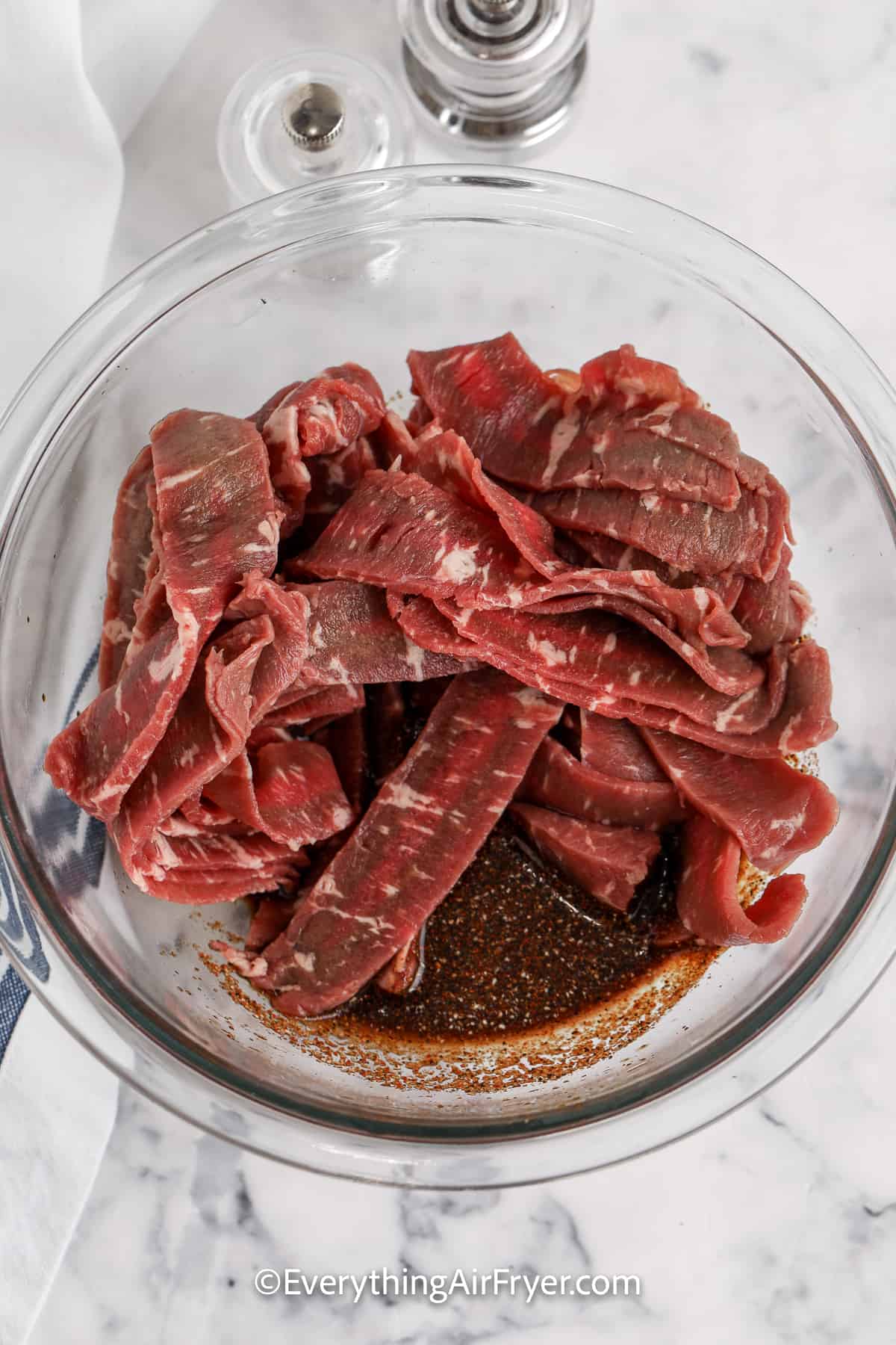 strips of uncooked in a bowl with marinade