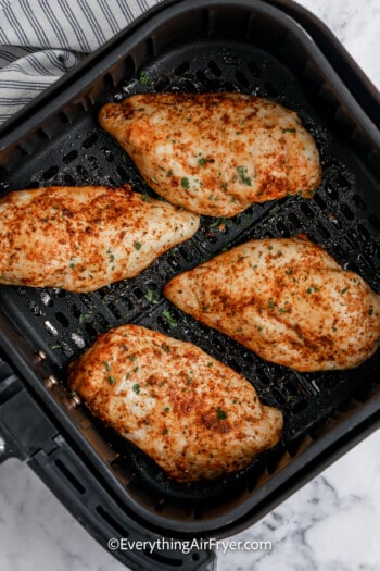 cooked chicken breasts in an air fryer tray