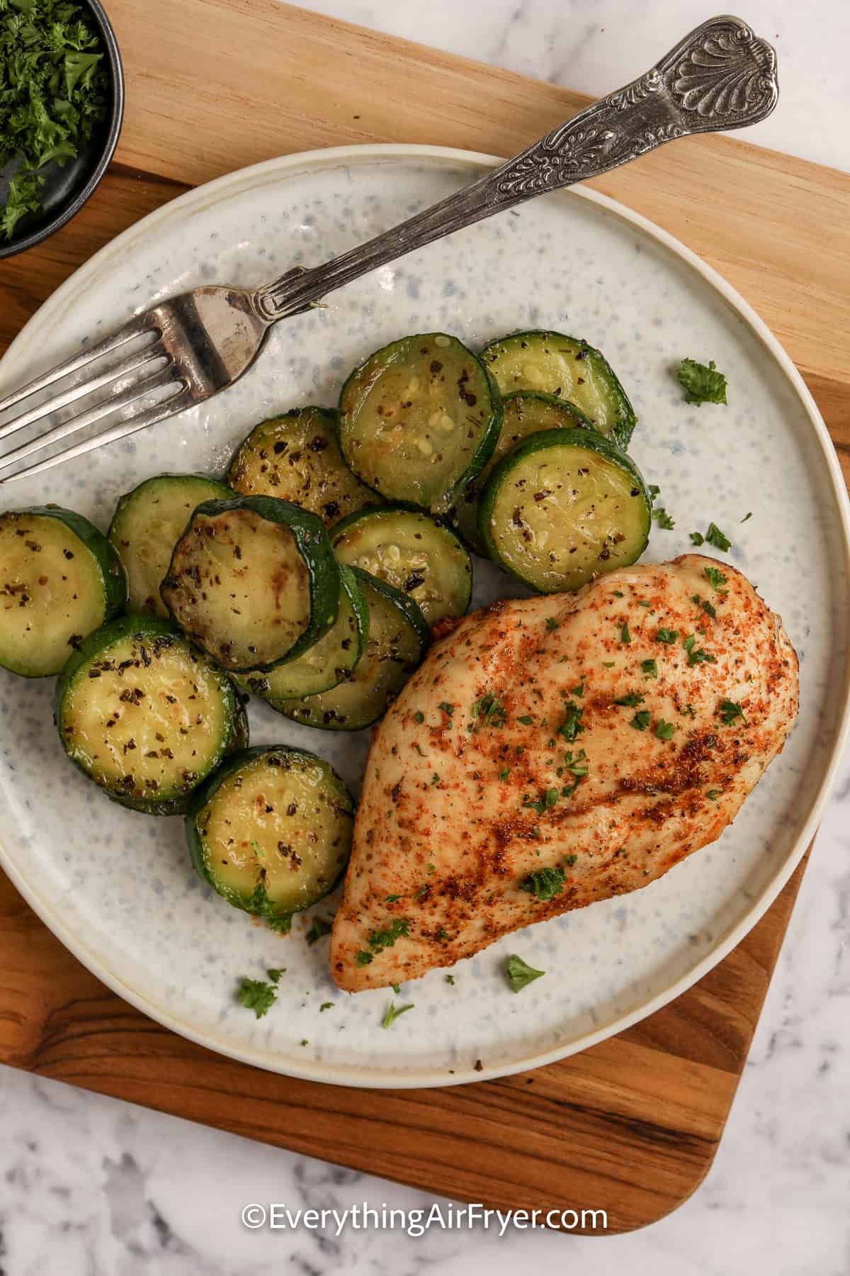 air fryer chicken breast on a plate with zucchini