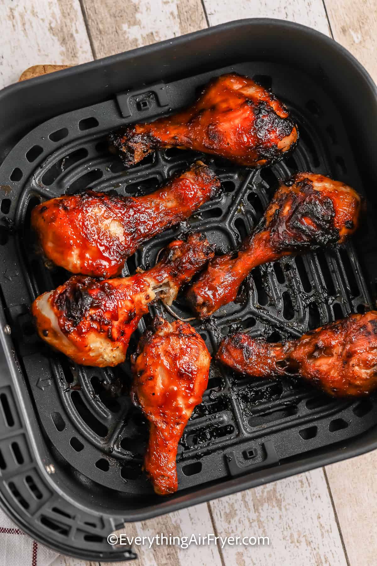cooked chicken drumsticks in an air fryer tray