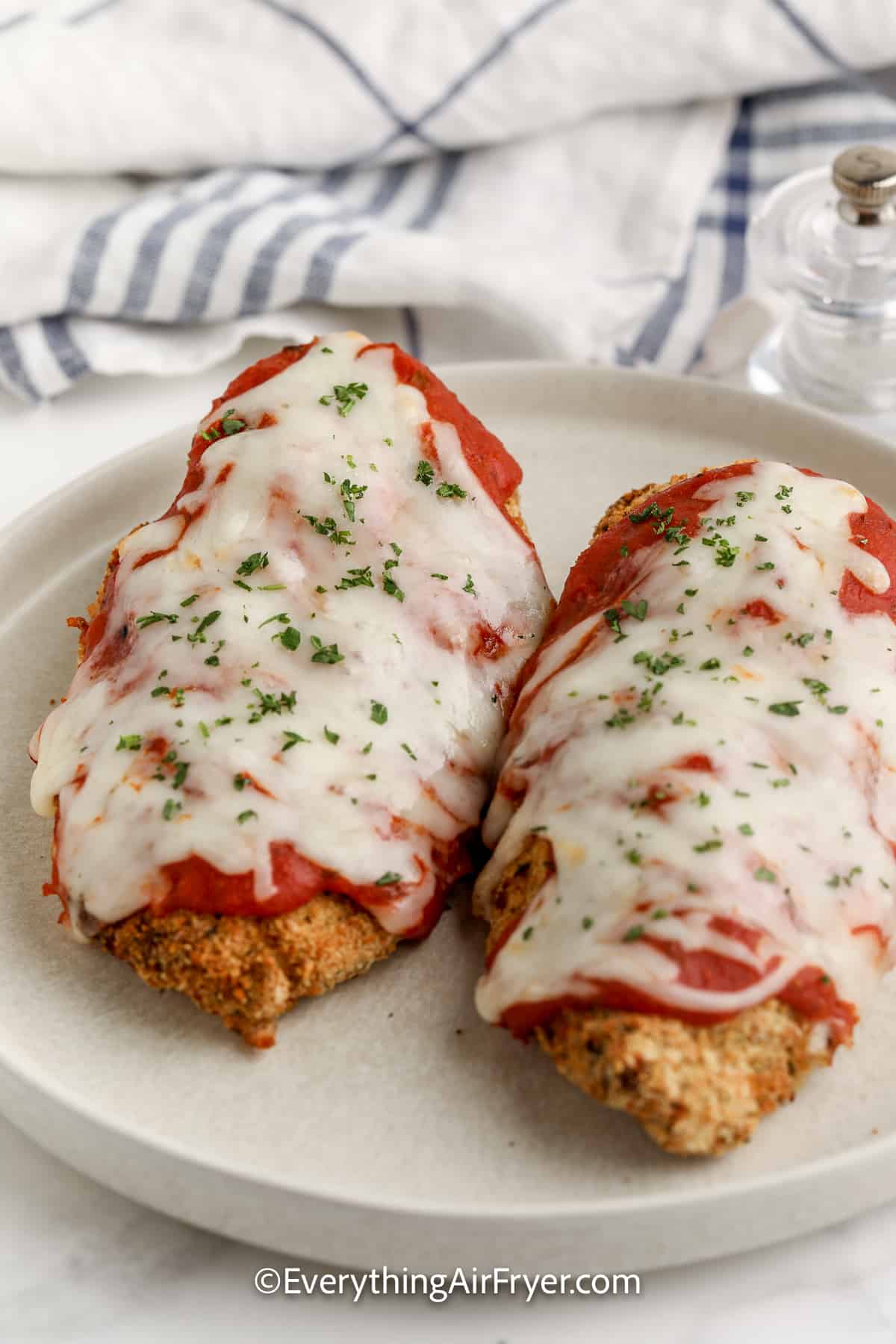 air fryer chicken parmesan on a plate topped with parsley