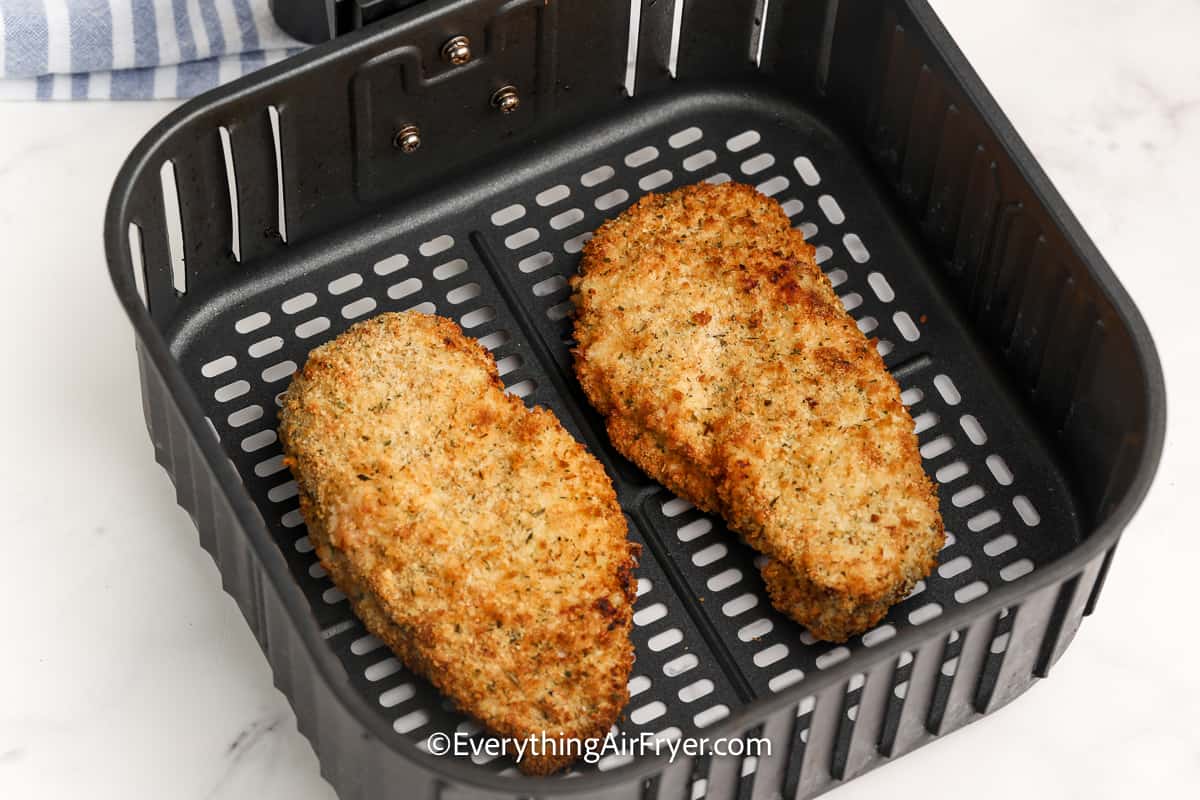 cooked breaded chicken breasts in an air fryer tray