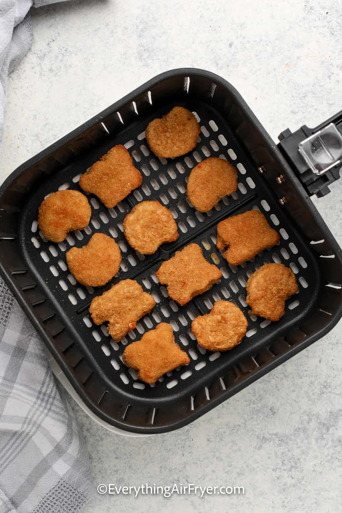 cooked chicken nuggets in an air fryer tray