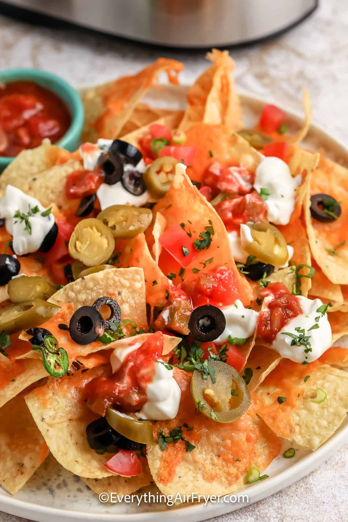 nachos with cheese jalapenos, olives, and salsa