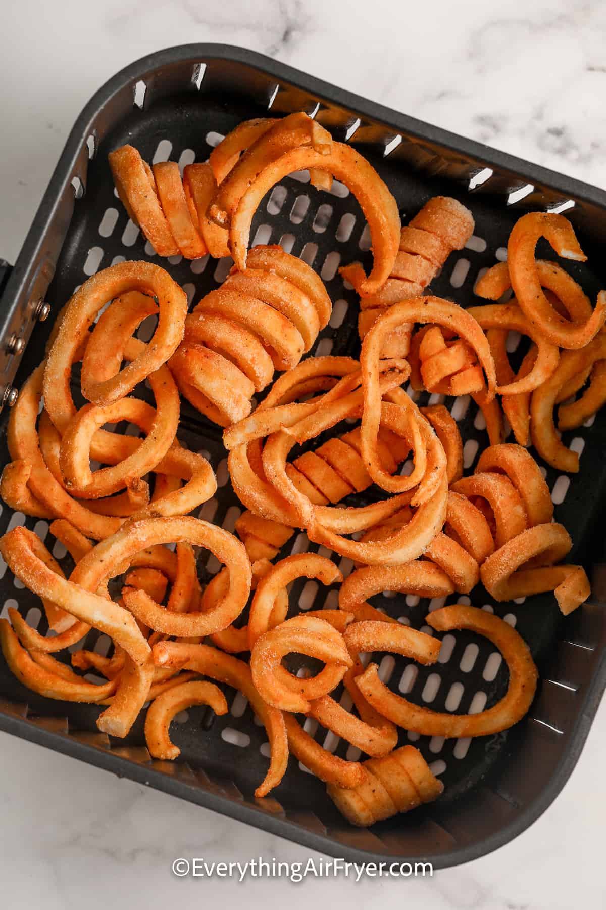 curly fries in an air fryer tray