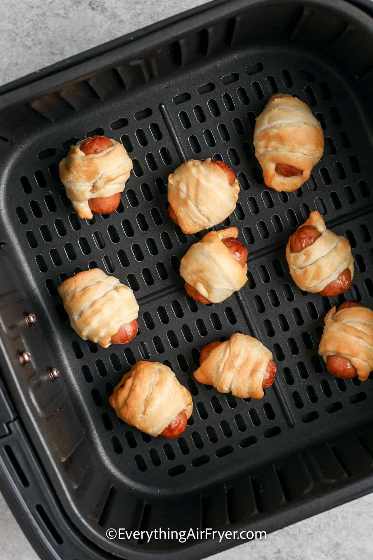 cooked air fryer pigs in a blanket in an air fryer tray