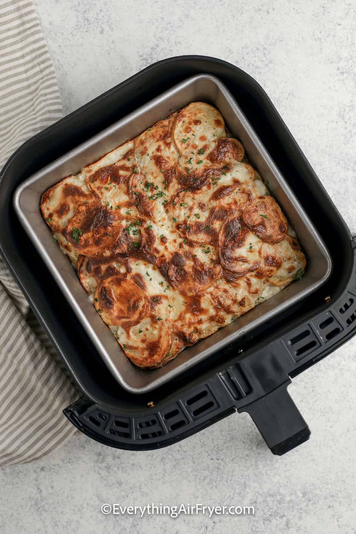 cooked air fryer scalloped potatoes in an air fryer tray