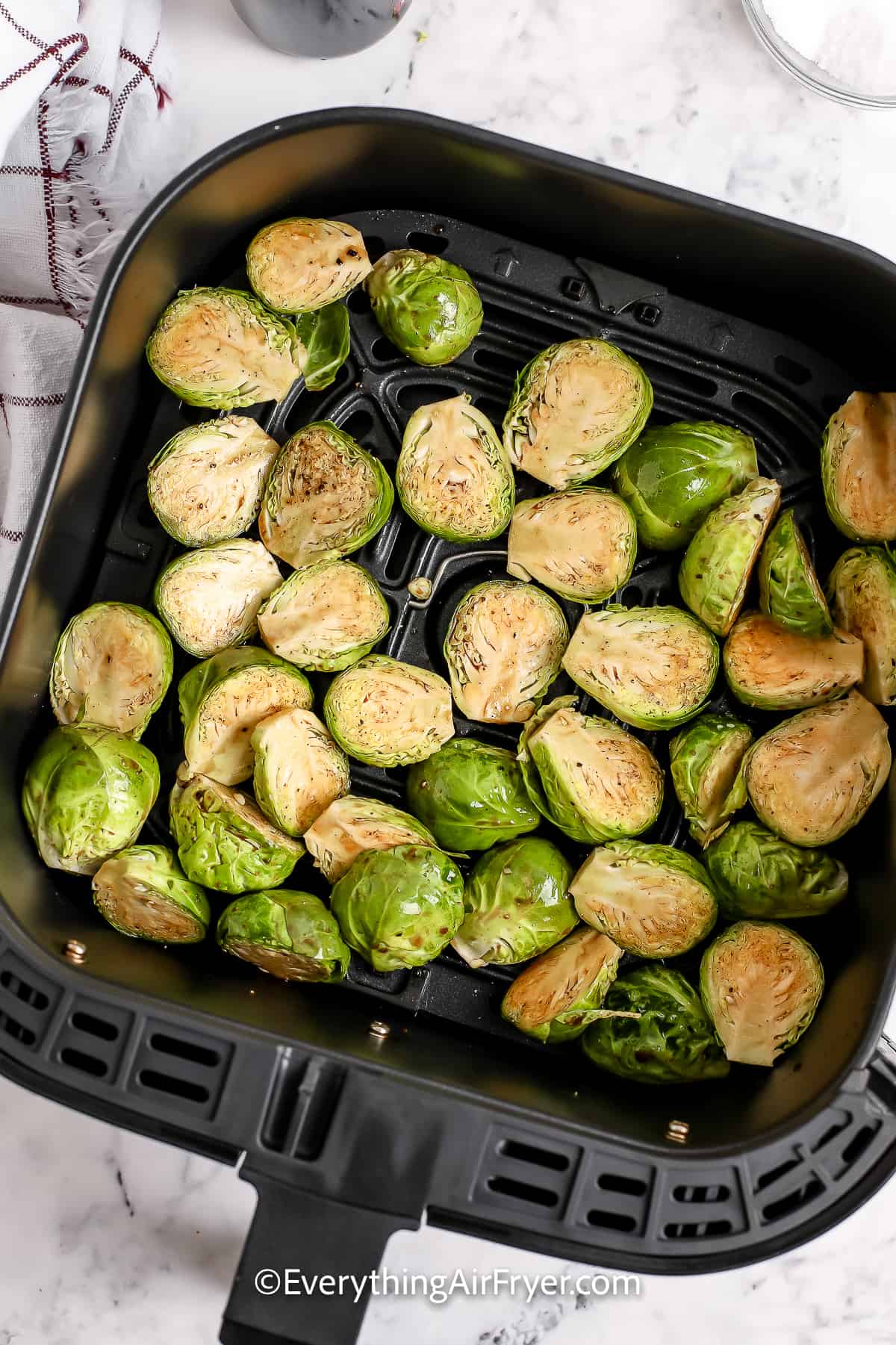 uncooked brussels sprouts in an air fryer tray
