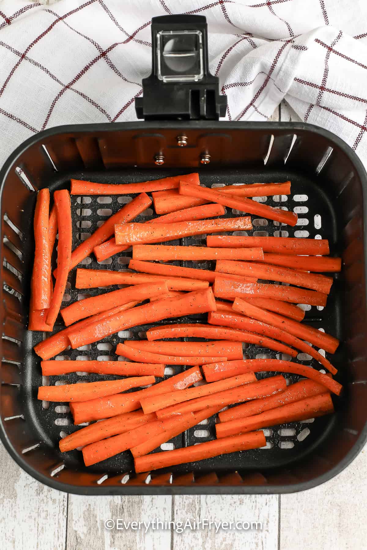 uncooked carrots in an air fryer tray