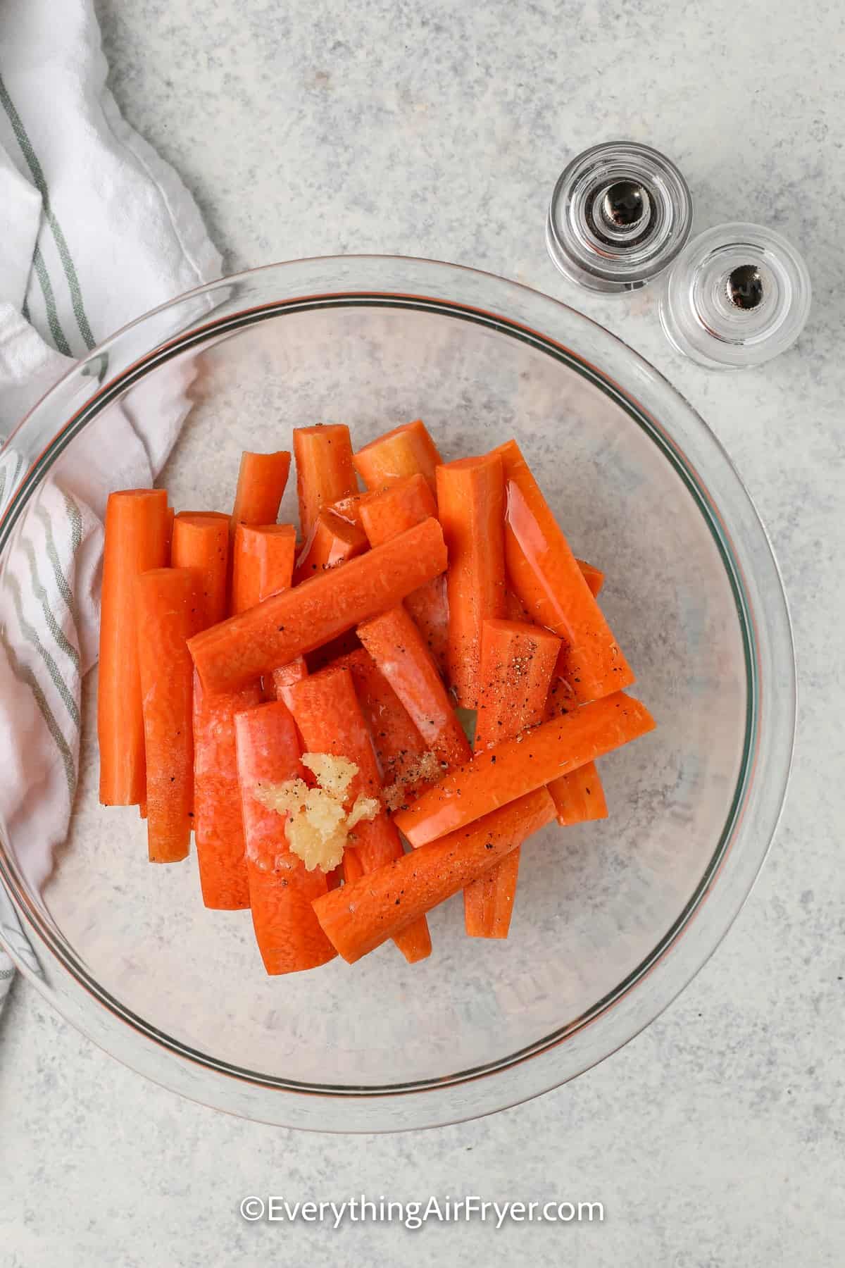 sliced carrots in a bowl with garlic and butter
