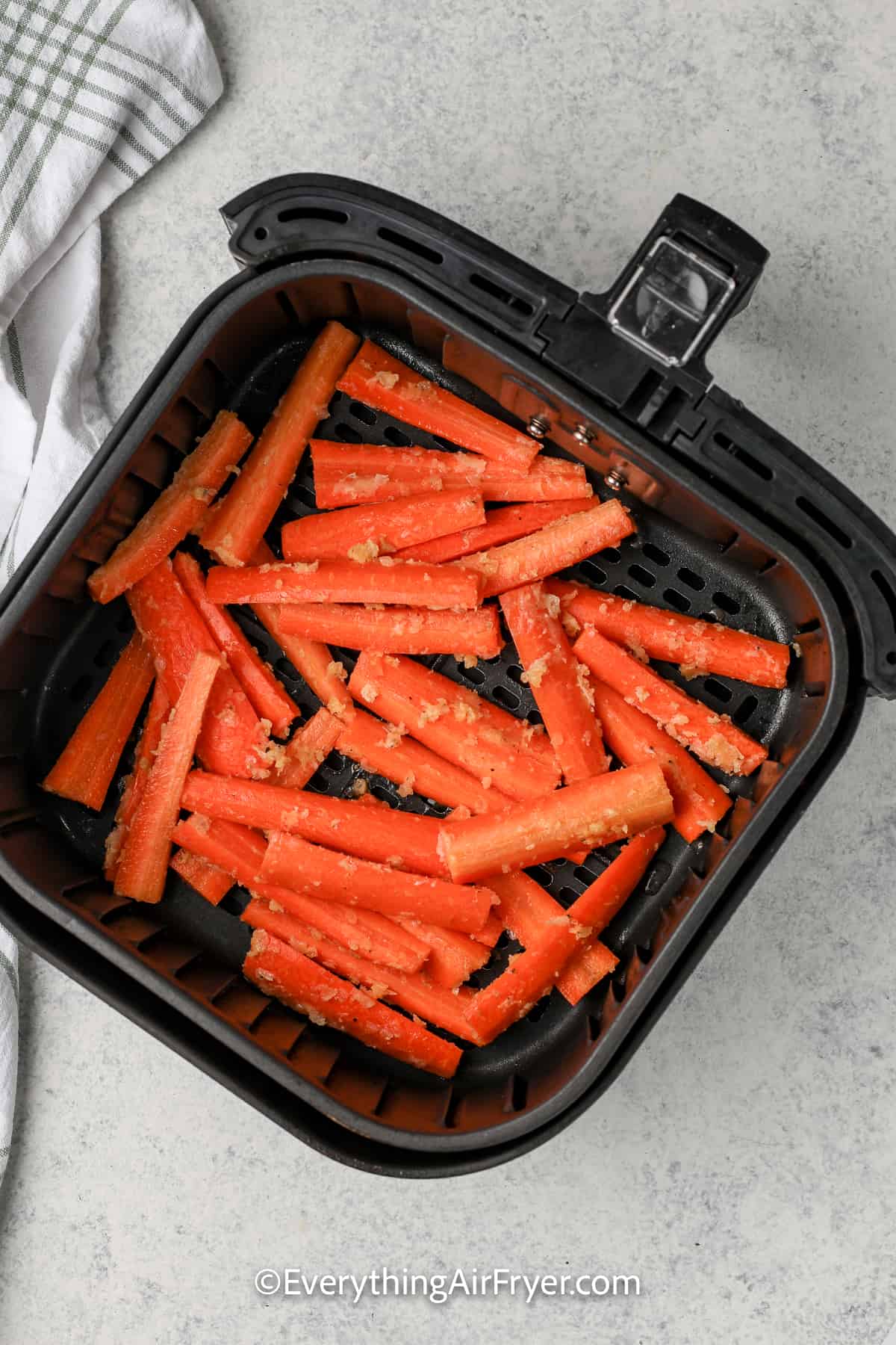 uncooked air fryer carrots in an air fryer tray
