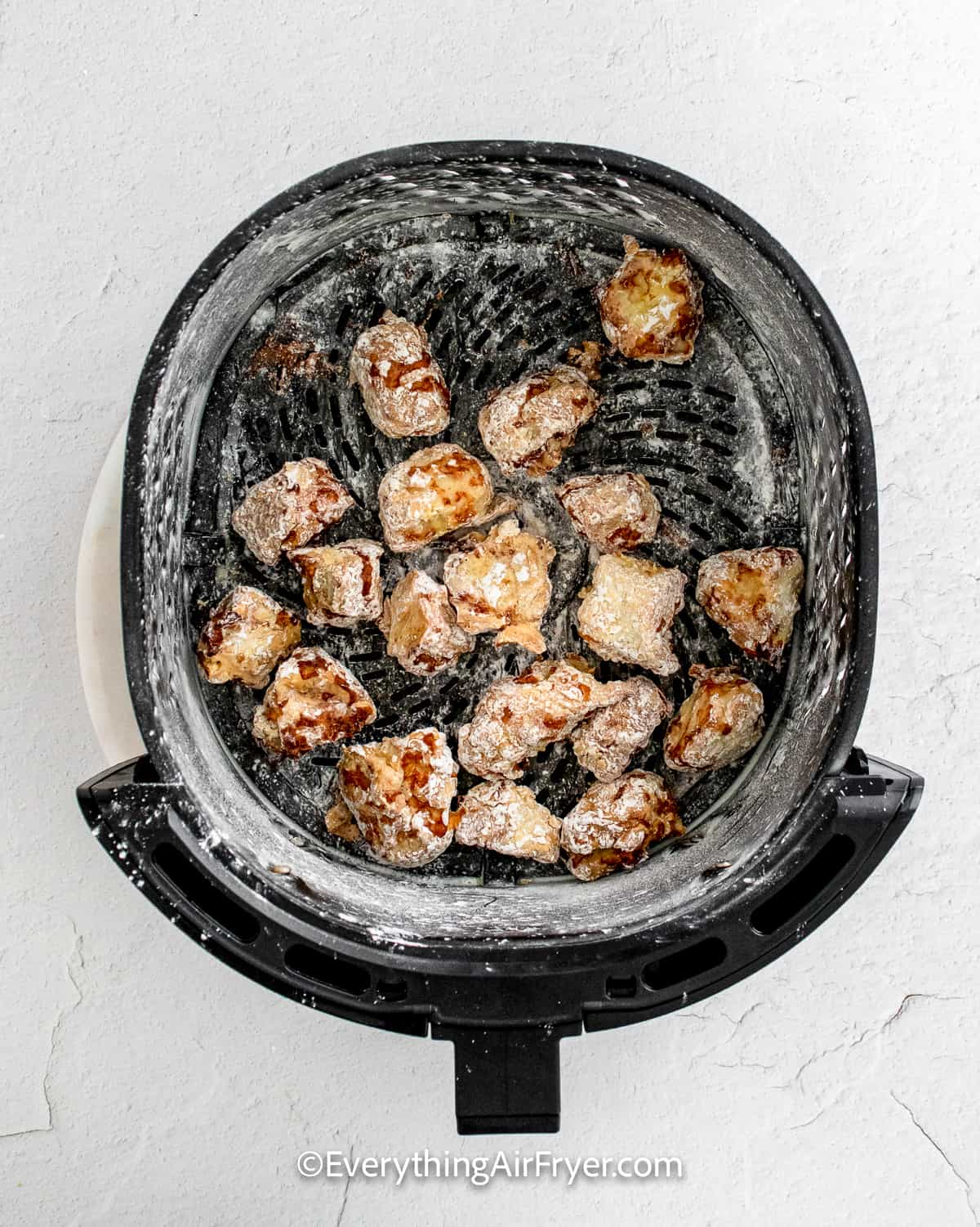 chicken chunks in an air fryer tray