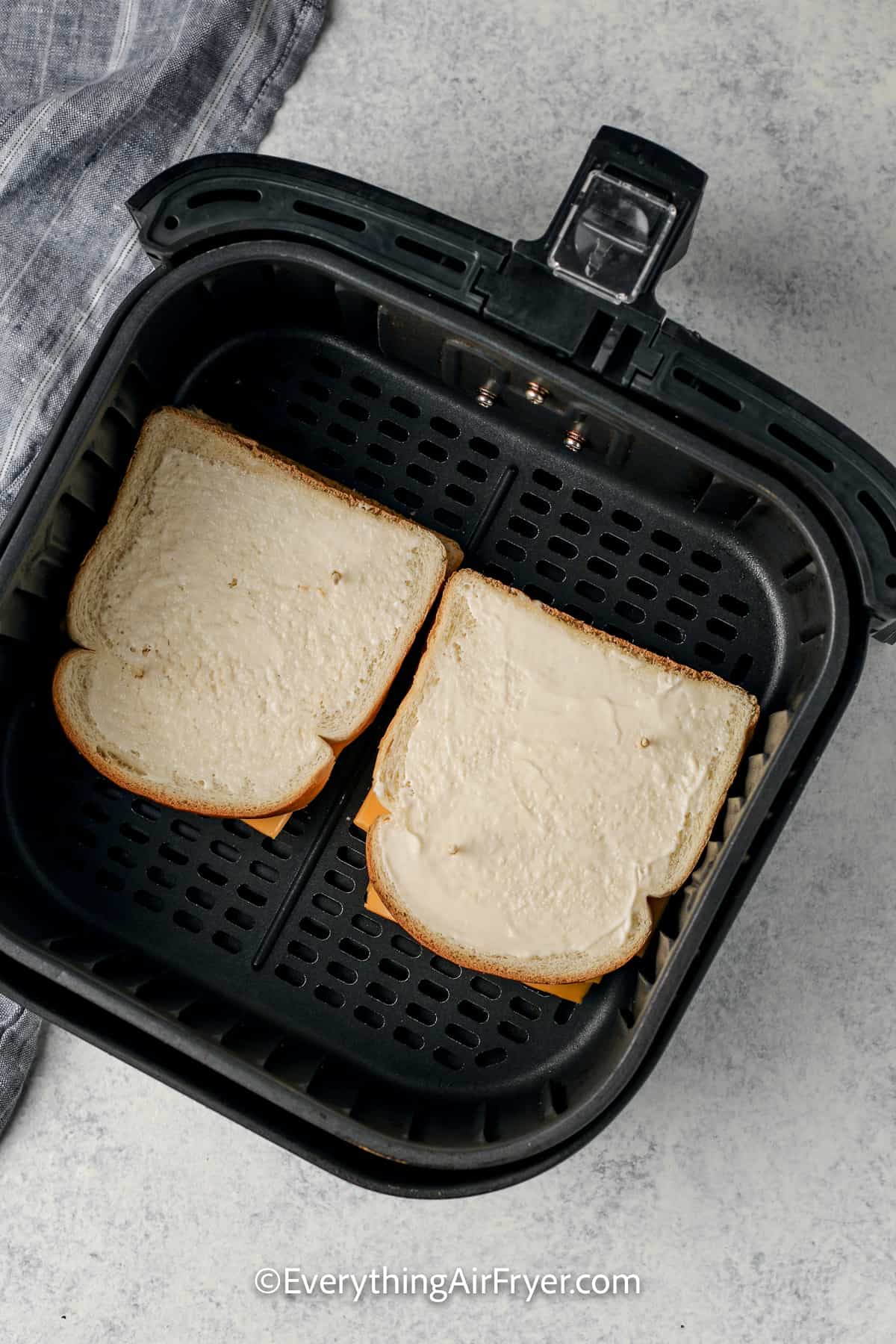 uncooked grilled cheese in an air fryer tray
