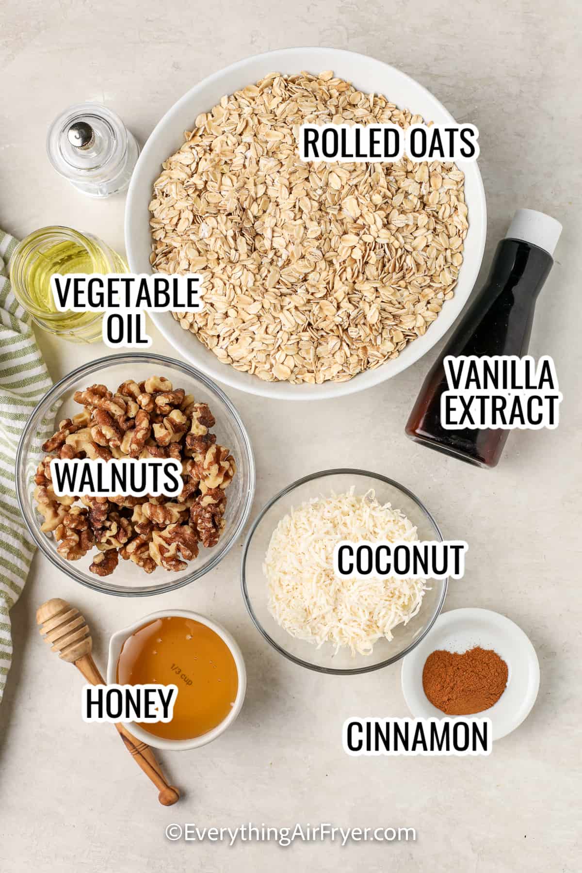 ingredients assembled to make air fryer granola including rolled oats, walnuts, honey, coconut, cinnamon, vanilla, and honey