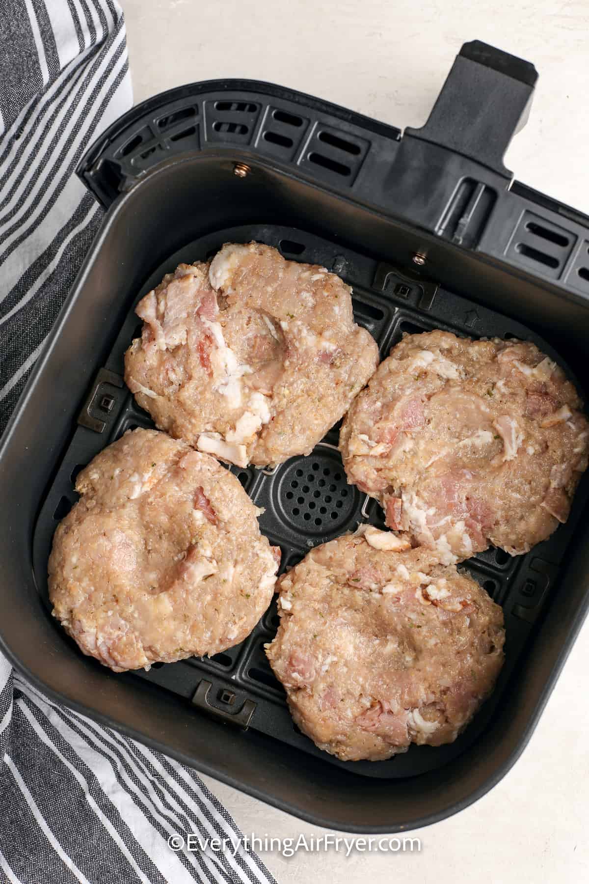 uncooked air fryer chicken burgers in an air fryer tray
