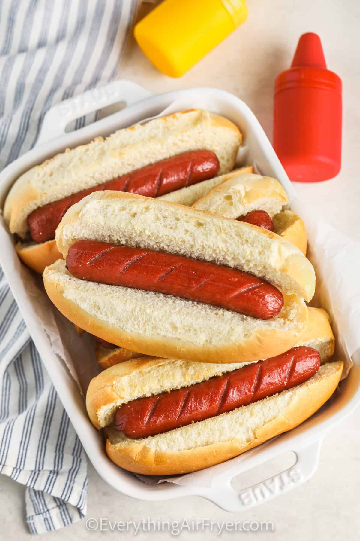 Air Fryer Hot Dogs in a dish with ketchup and mustard