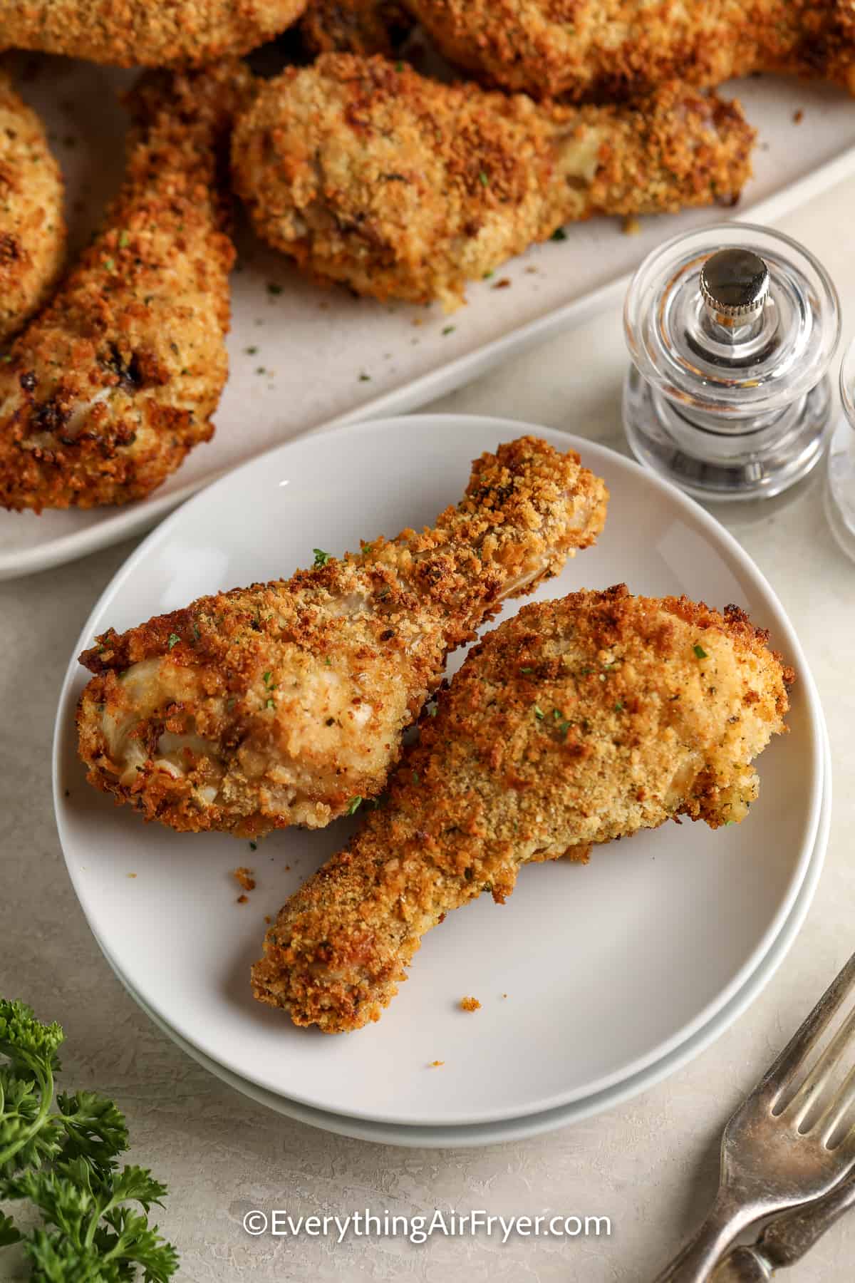 two breaded air fryer chicken drumsticks on a plate
