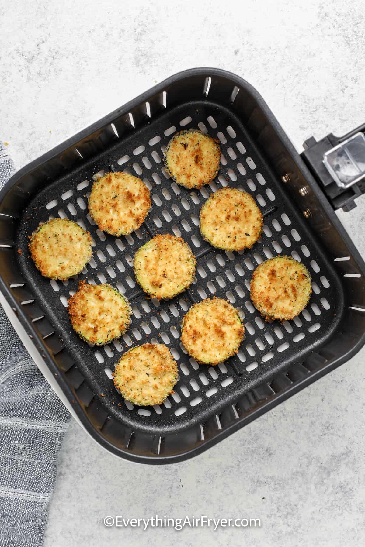 cooked air fryer zucchini chips in an air fryer tray