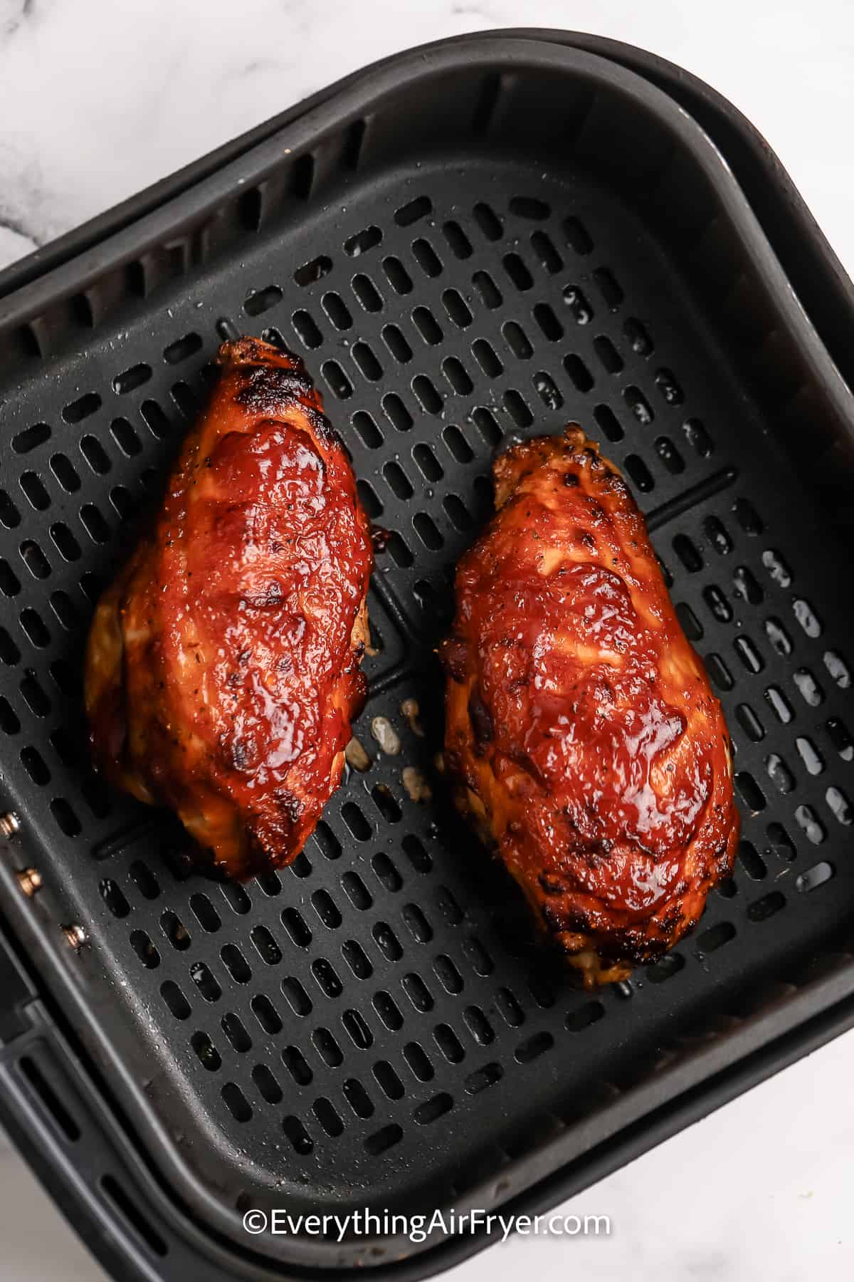 cooked air fryer bbq chicken breasts in an air fryer tray