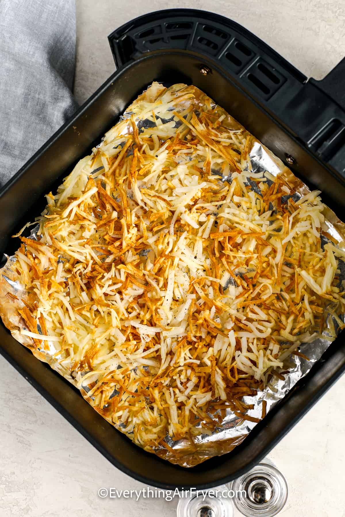 cooked hash browns in an air fryer tray