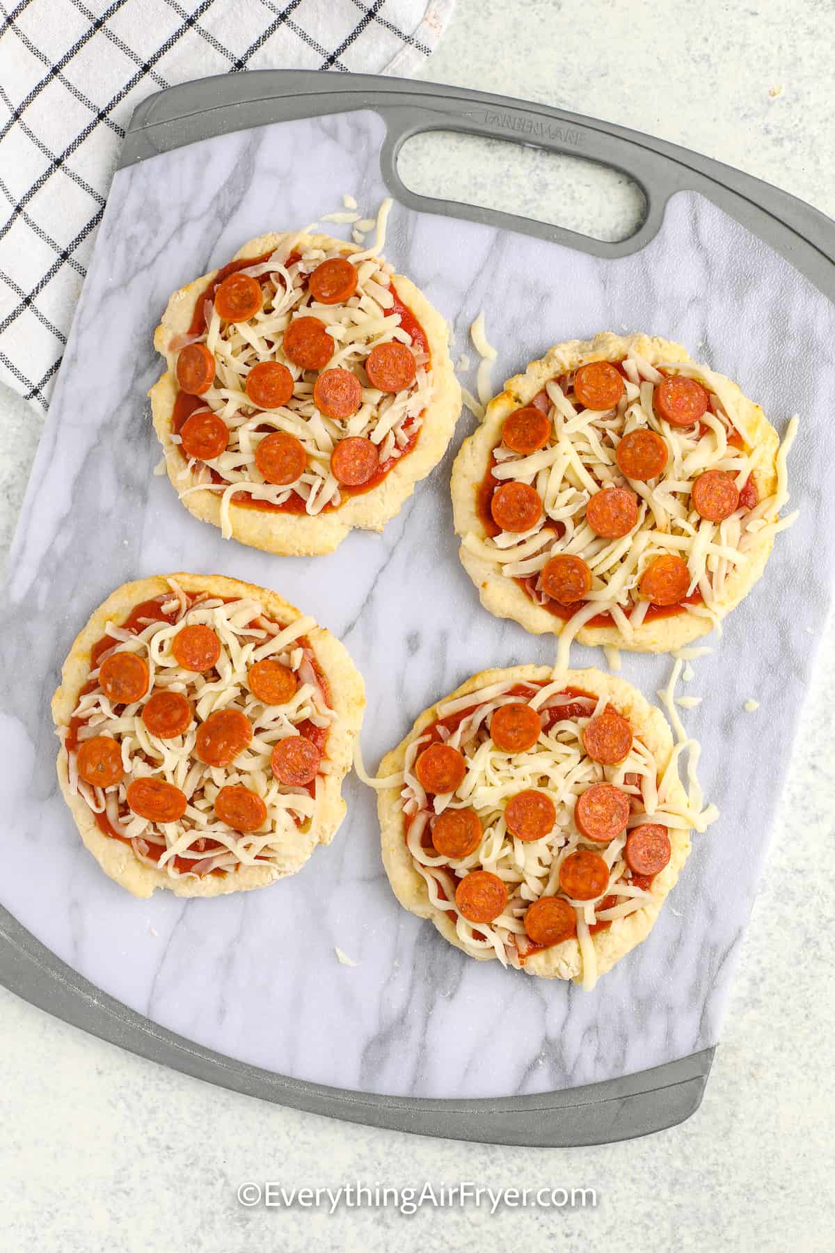 unbaked air fryer pizza on a cutting board