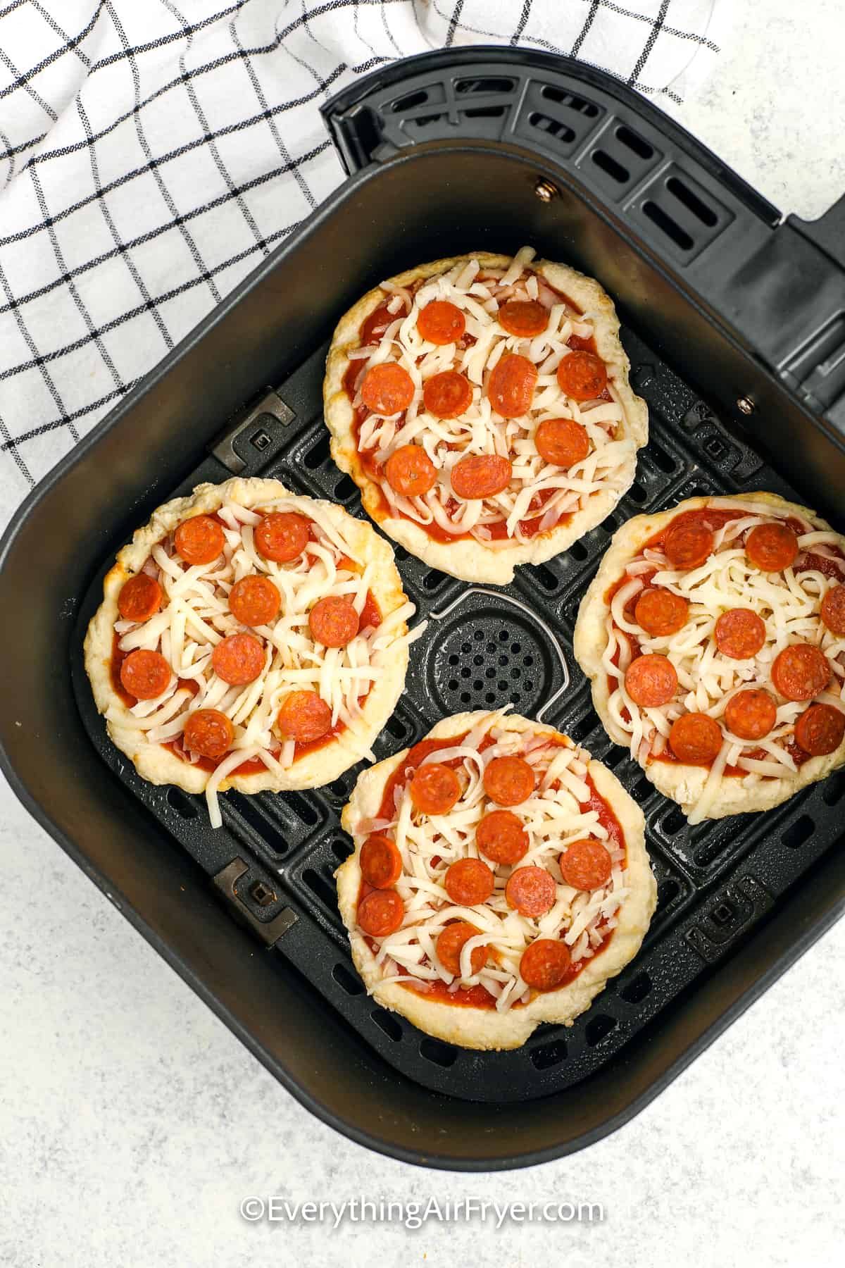 uncooked air fryer pizza in an air fryer tray