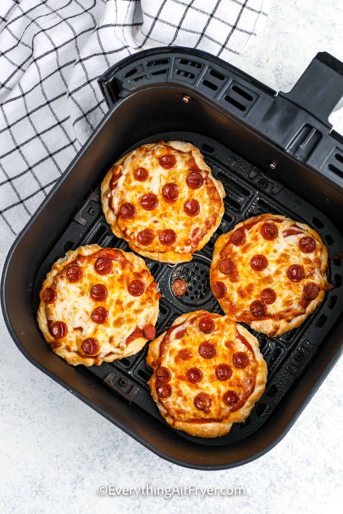 cooked air fryer pizza in an air fryer tray