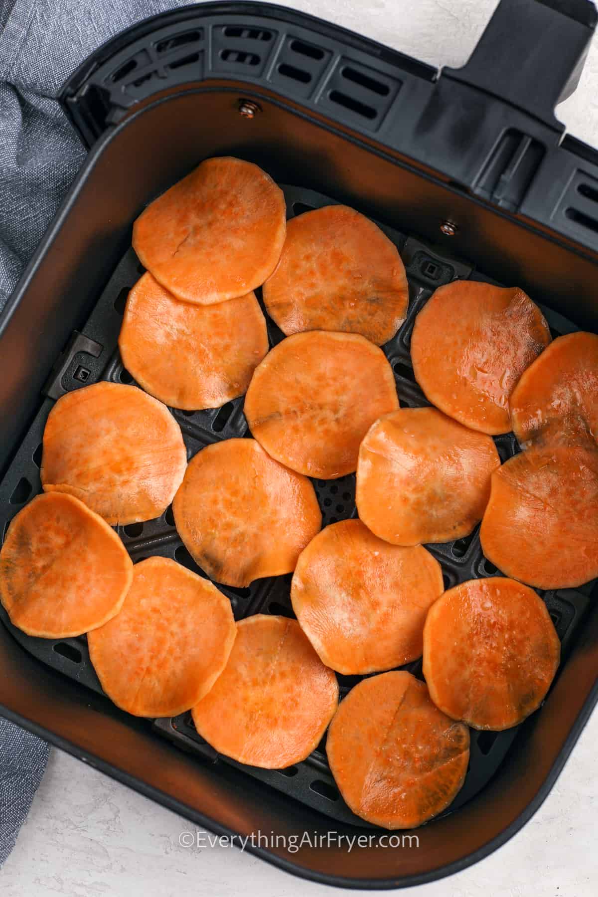 Sweet potato slices in an air fryer basket