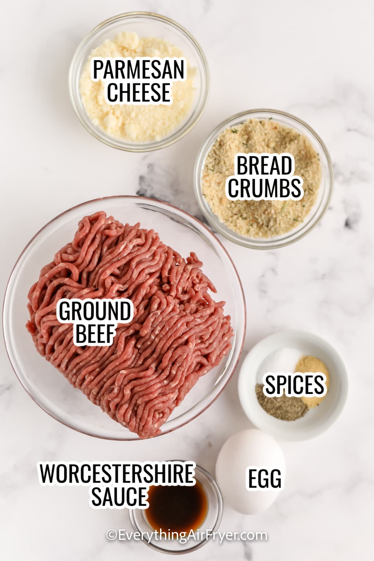 ingredients assembled to make air fryer meatballs , including ground beef, parmesan cheese, bread crumbs, spices, worcestershire sauce, and eggs