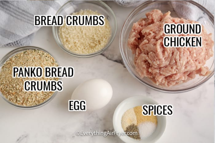 ingredients assembled to make homemade chicken nuggets including ground chicken, bread crumbs, egg, and spices
