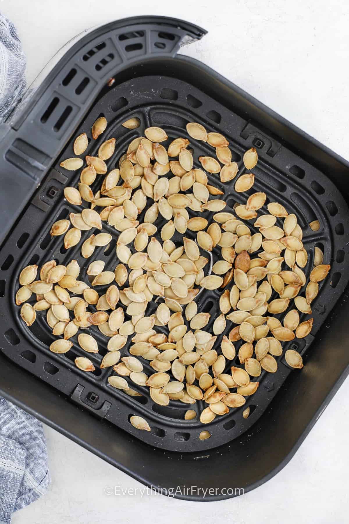 pumpkin seeds being baked in an air fryer