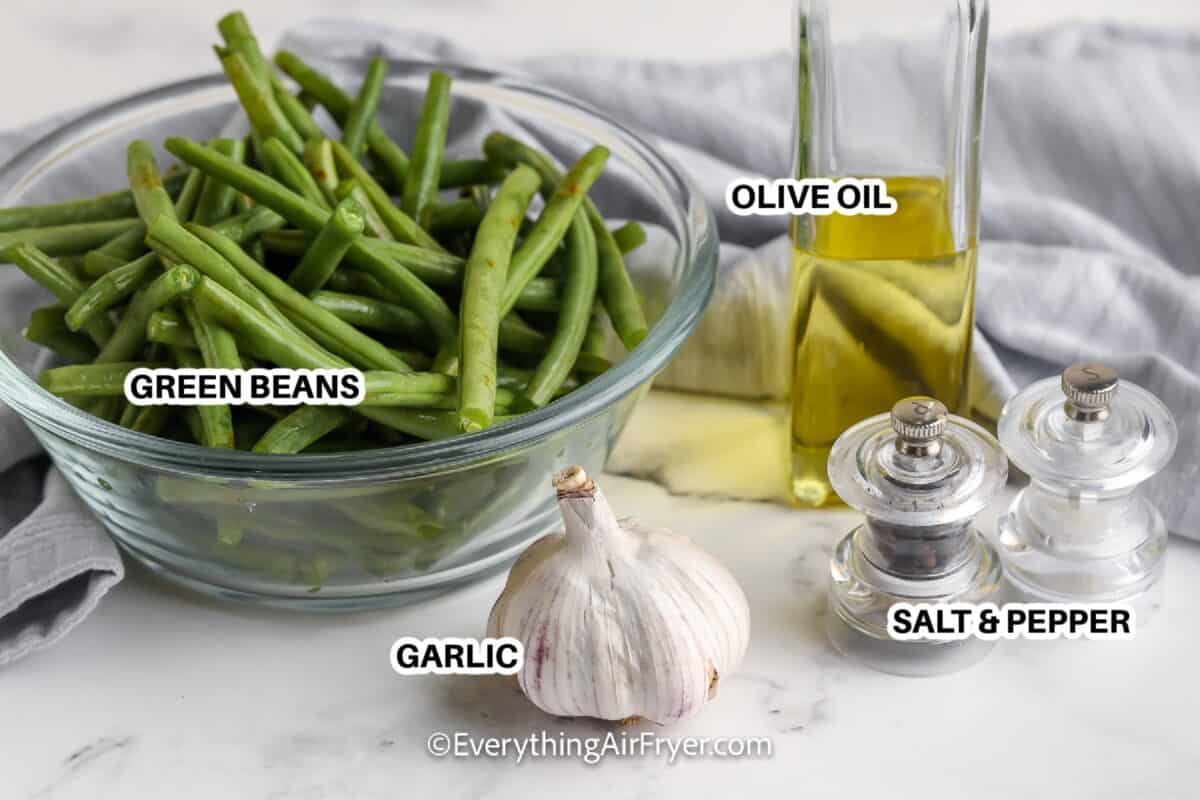 Ingredients to make air fryer green beans labeled: green beans, garlic, olive oil, salt, and pepper
