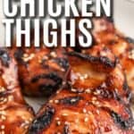 Air Fryer boneless chicken thighs on a serving plate topped with sesame seeds with text