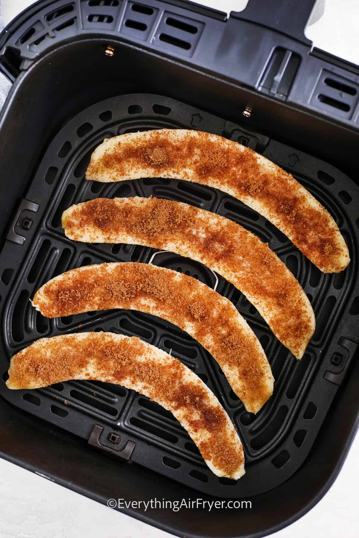 uncooked bananas in an air fryer tray
