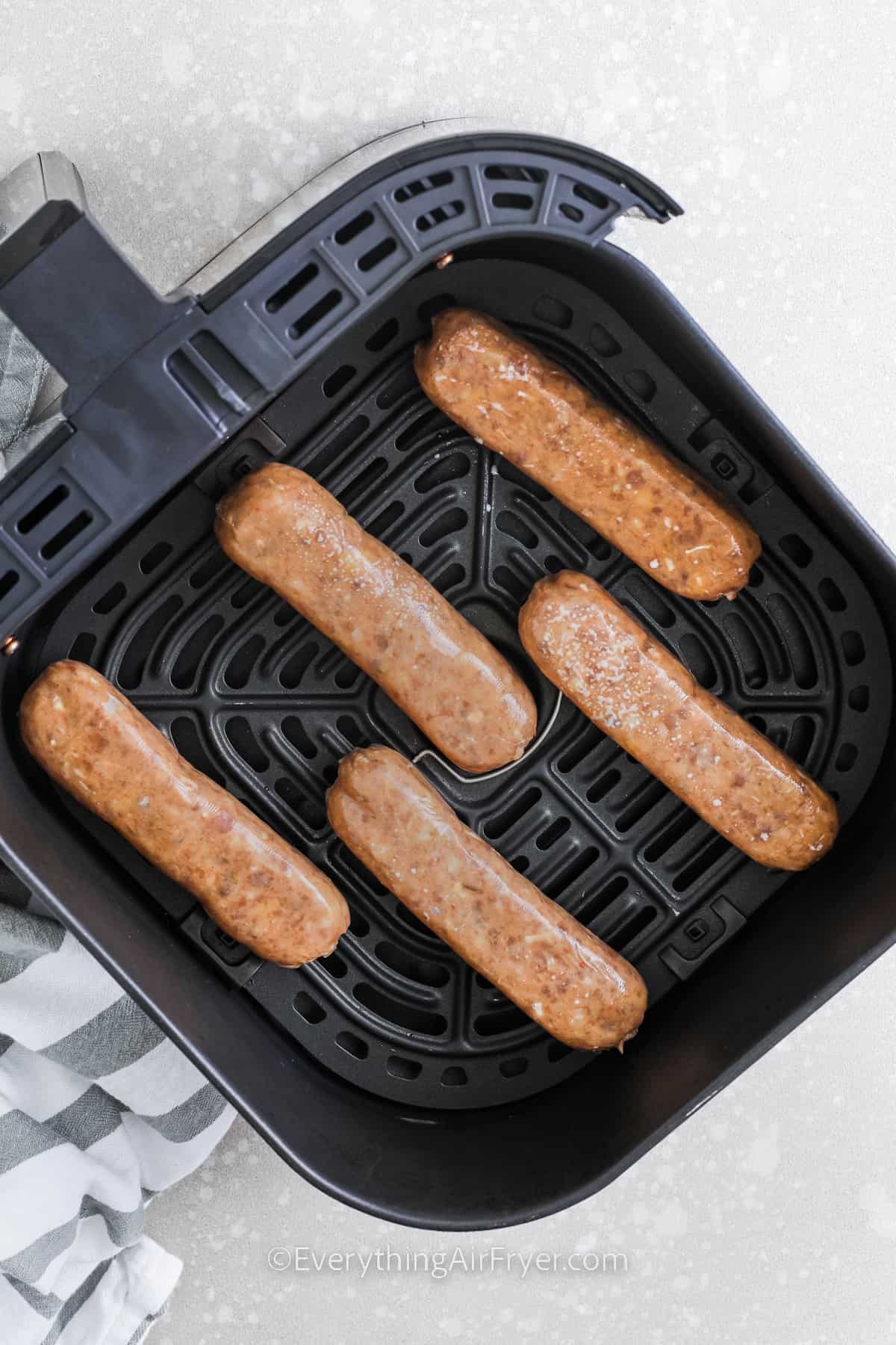 Air fryer chicken sausage in an air fryer basket before being cooked
