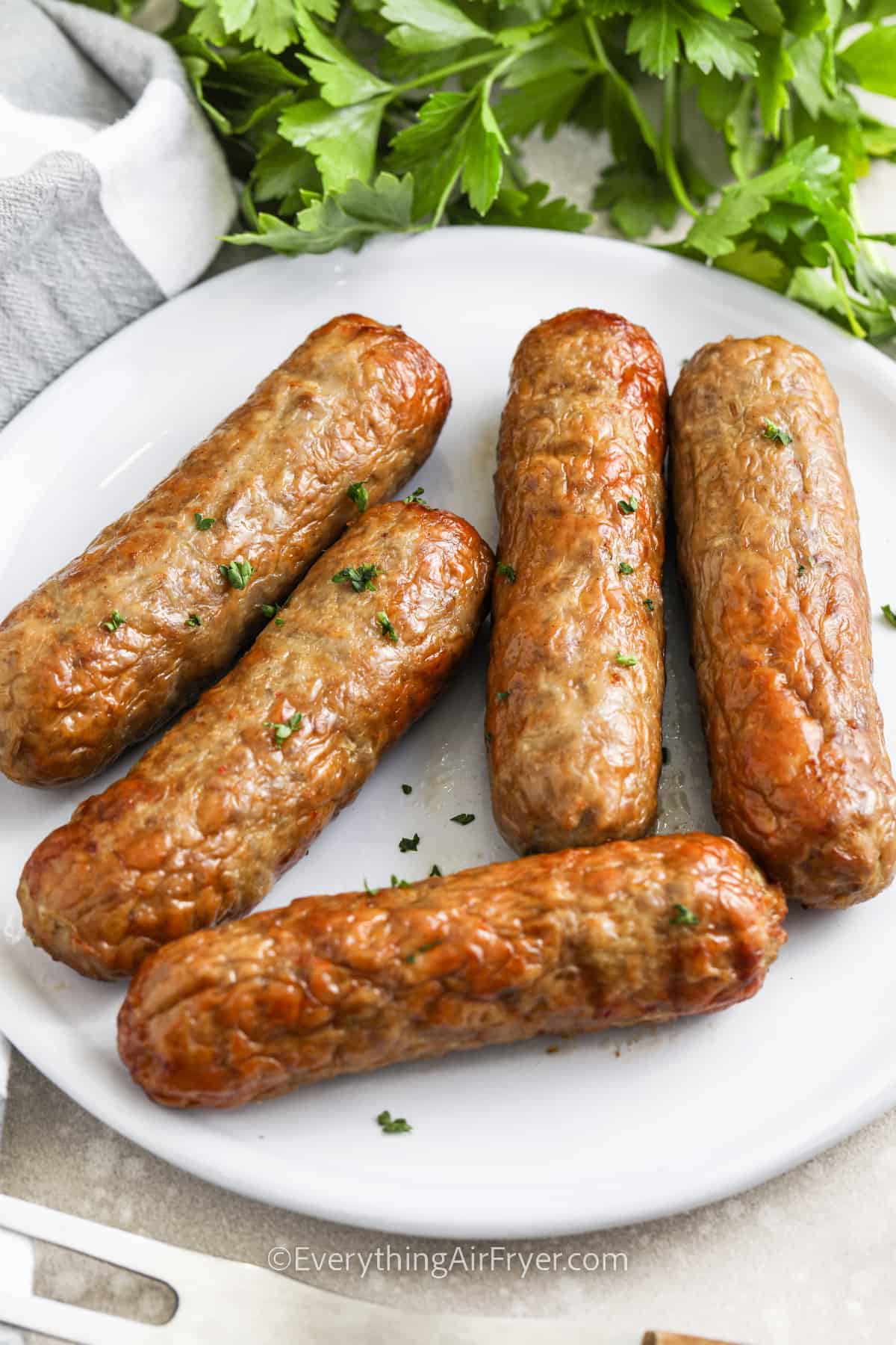 Air fryer chicken sausage on a plate with parsley as garnish
