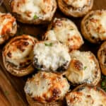 air fryer stuffed mushrooms stacked on a cutting board