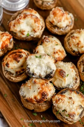 air fryer stuffed mushrooms stacked on a cutting board