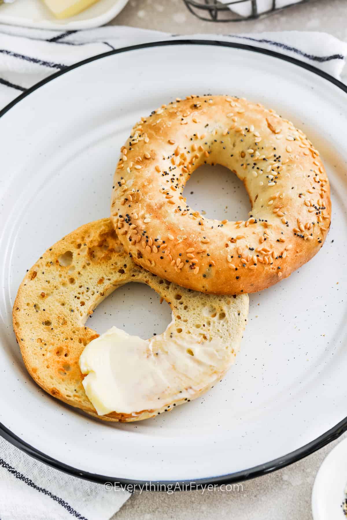 toasted bagel on a white plate with butter