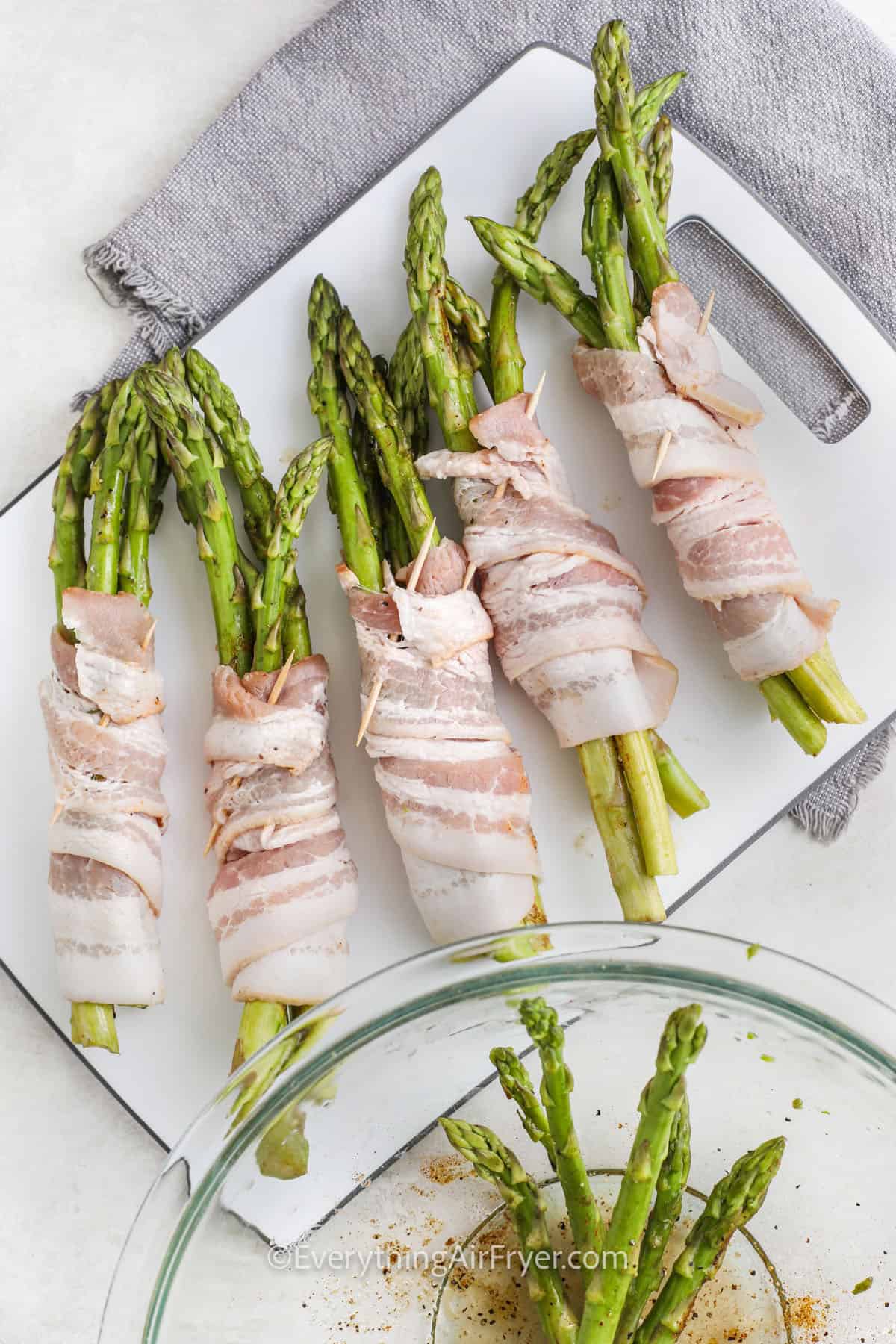 wrapping asparagus in bacon to make Air Fryer Bacon Wrapped Asparagus