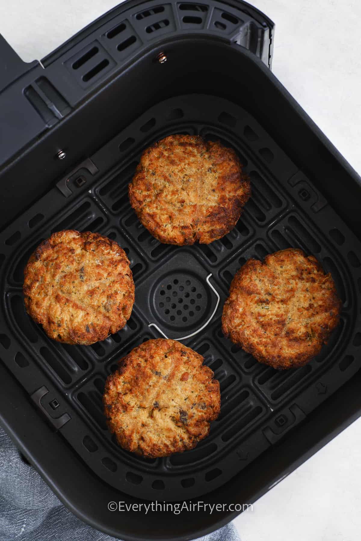 salmon patties cooked in an air fryer basket