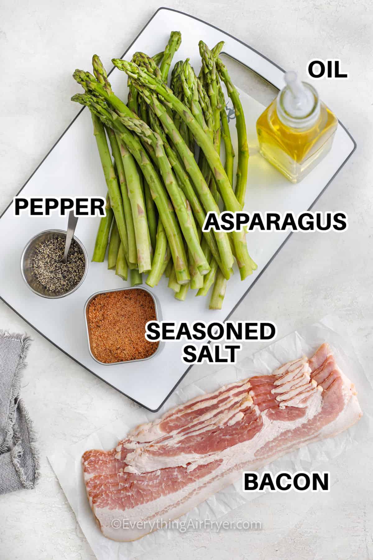 asparagus , pepper , seasoned salt , oil and bacon with labels to make Air Fryer Bacon Wrapped Asparagus