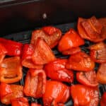 roasted red peppers in an air fryer basket with text