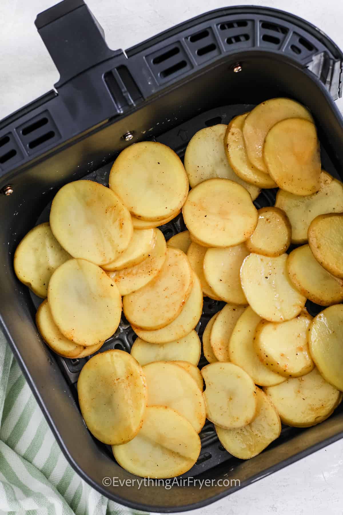 adding potato slices to fryer to make Sliced Potatoes in the Air Fryer