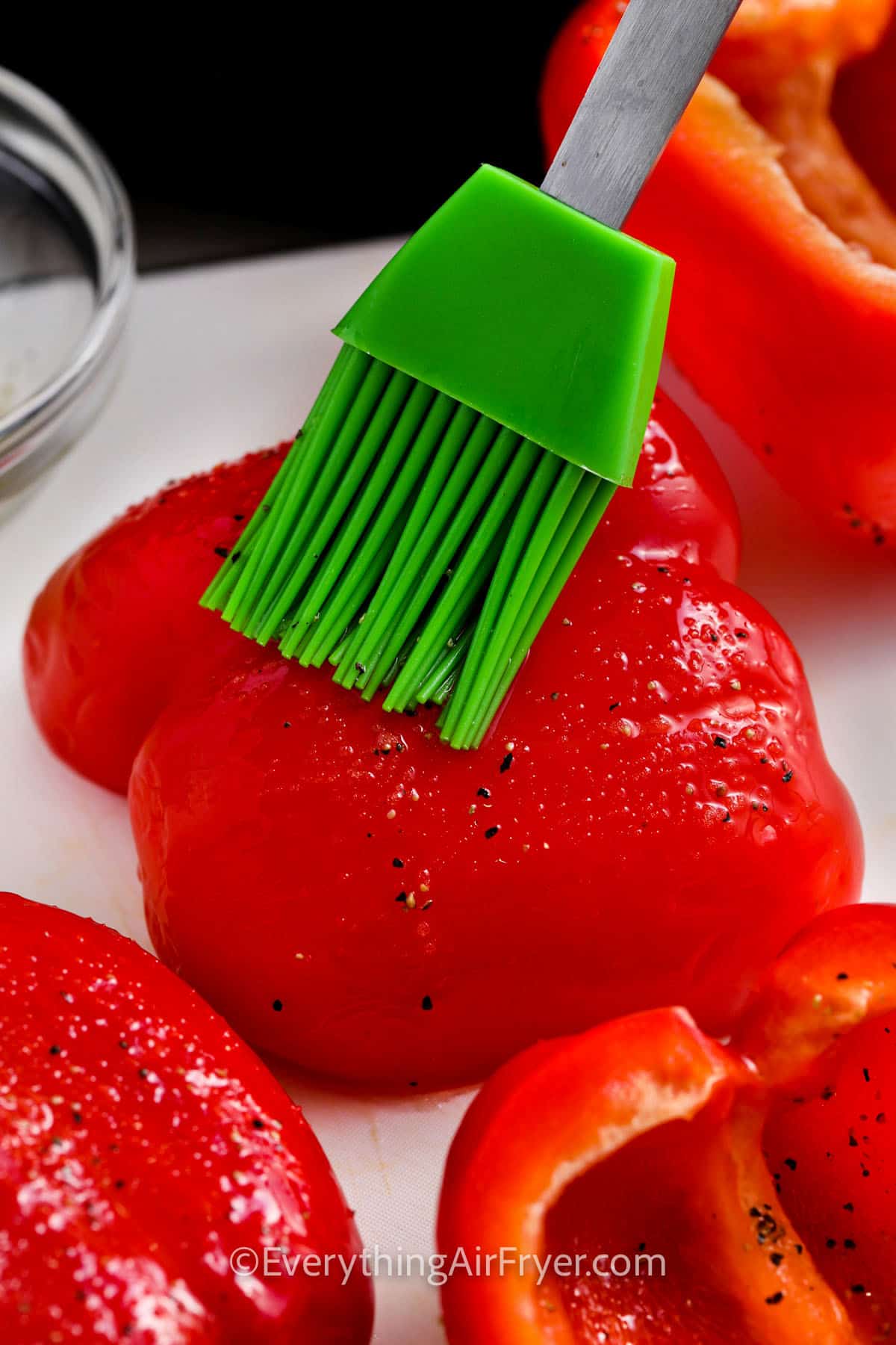 brushing butter over peppers to make Air Fryer Roasted Peppers
